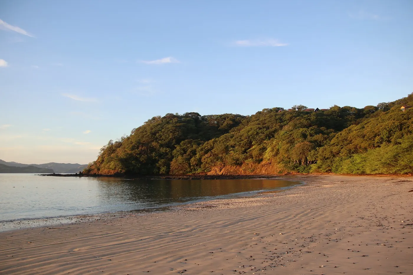 A quiet beach below a forested headland on the Papagayo Peninsula